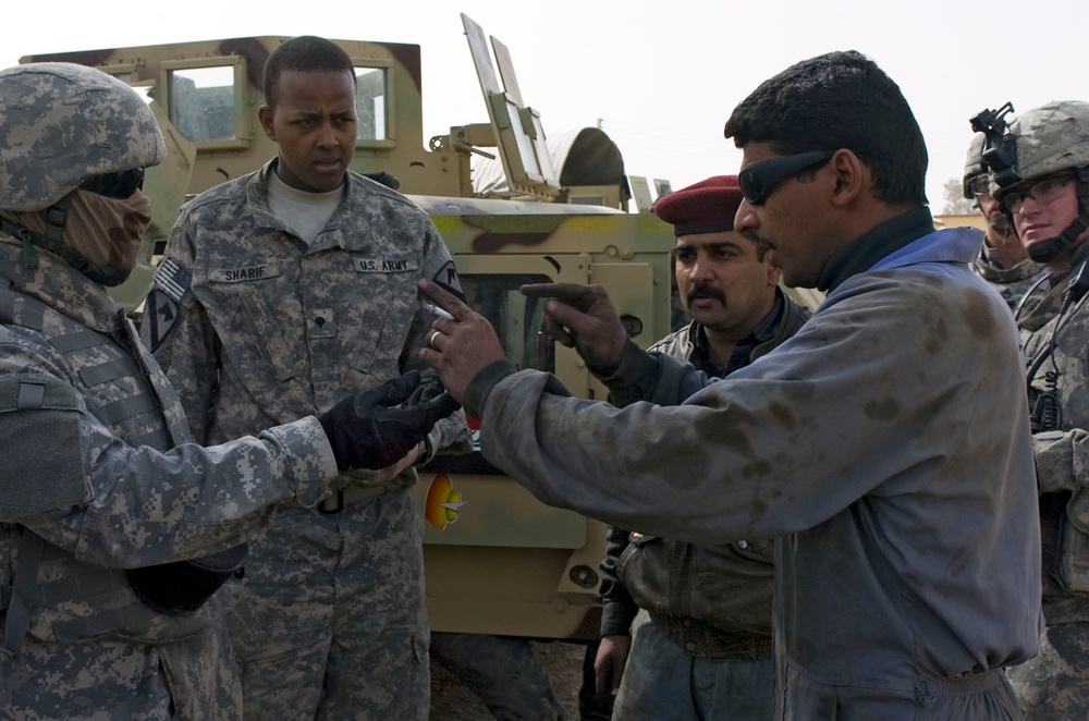 Coalition and Iraqi Army mechanics work to repair broken vehicles