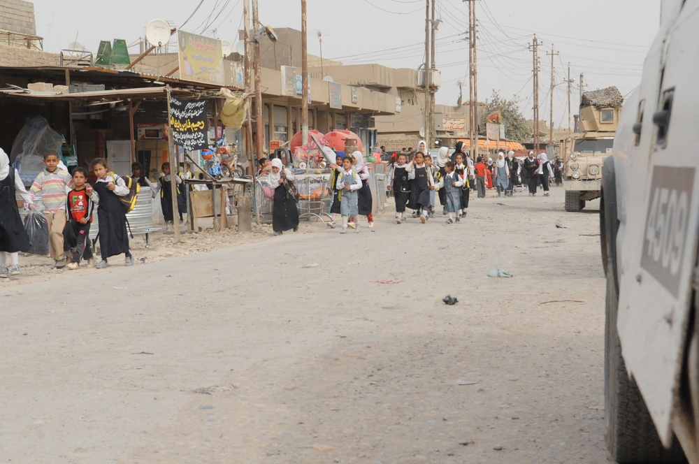 Soldiers, Iraqi national policemen distribute school supplies in Baghdad
