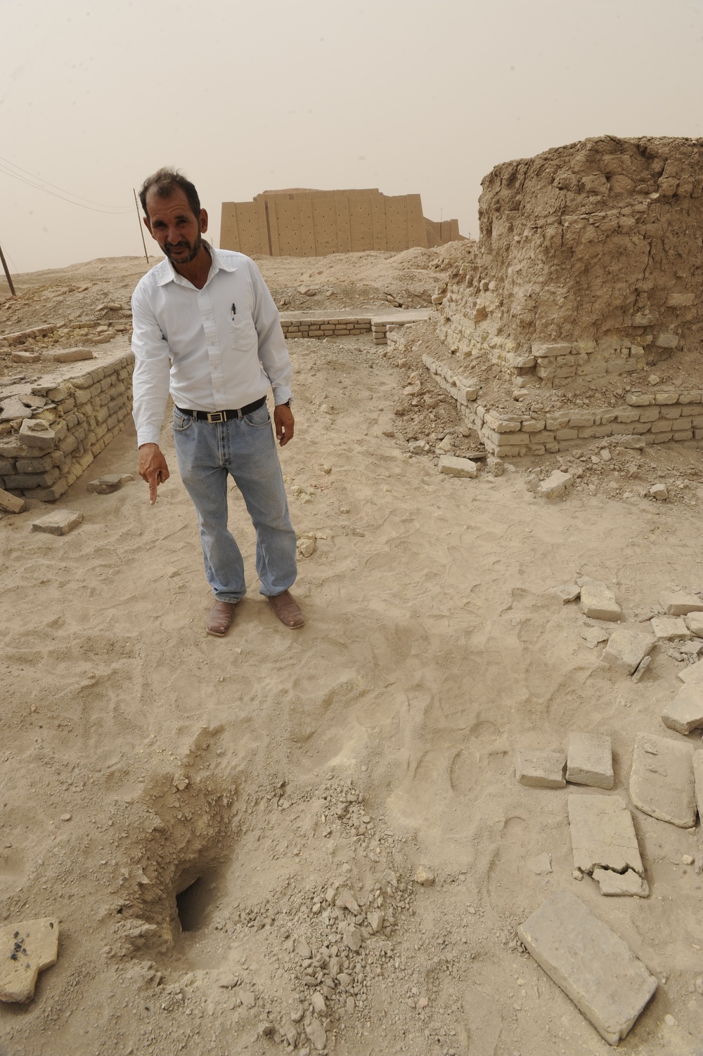 Iraqi security members inspect rocket crater at ancient site