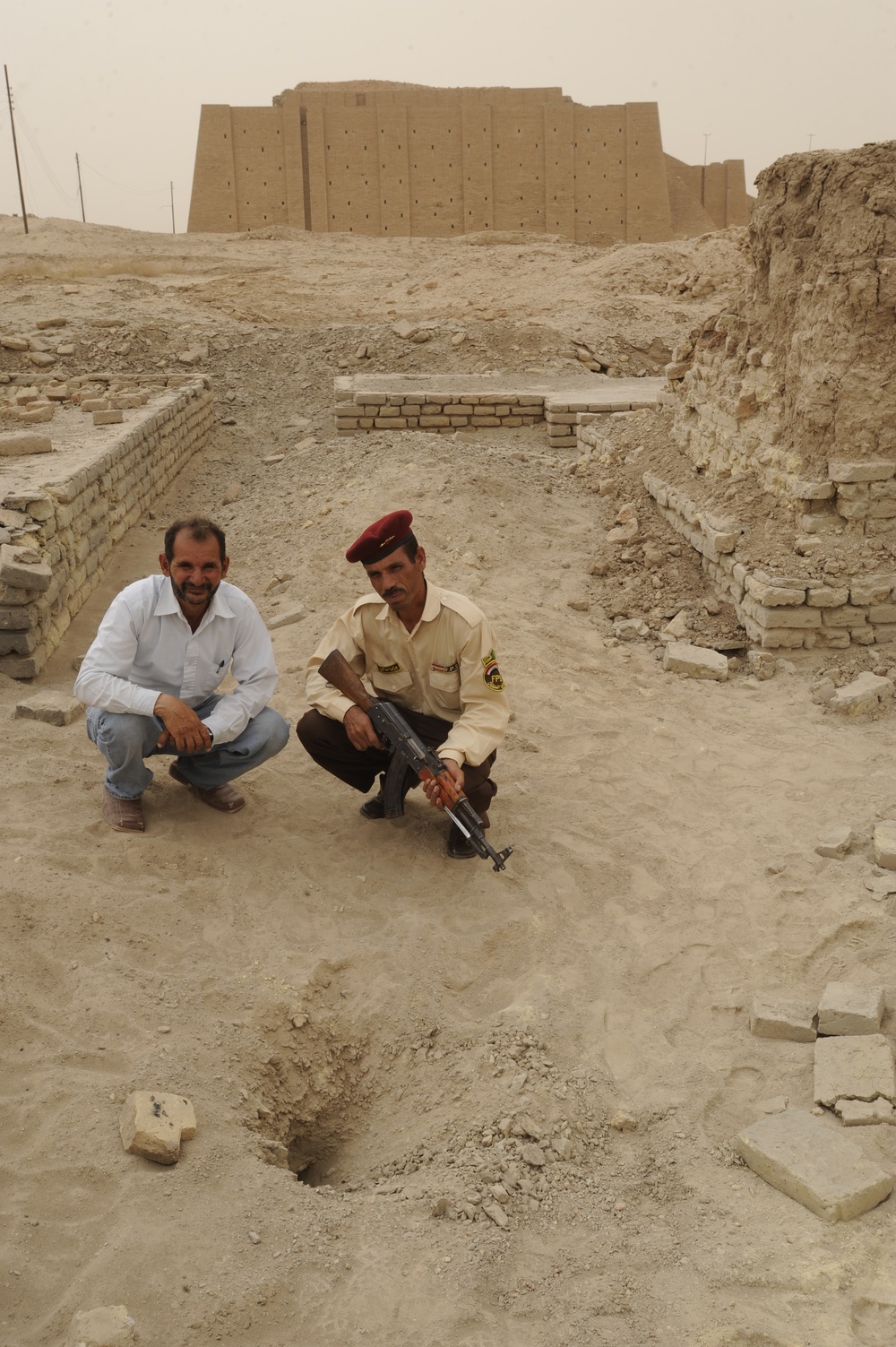 Iraqi security members inspect rocket crater at ancient site