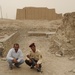 Iraqi security members inspect rocket crater at ancient site