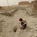 Iraqi security members inspect rocket crater at ancient site