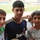 Three young teenage boys pose together for a photo at what appears to be a football/soccer stadium. They are wearing football jerseys from well-known clubs including Real Madrid (bwin/LFP sponsor era) and Liverpool FC. The setting suggests a youth football event or match day at a large stadium.