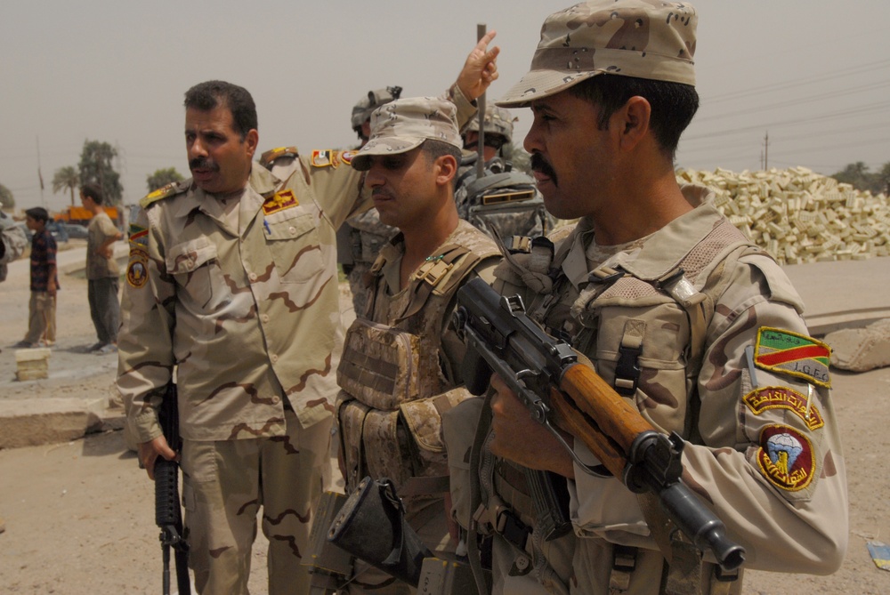 Iraqi soldiers plan a patrol through Abu Ghraib