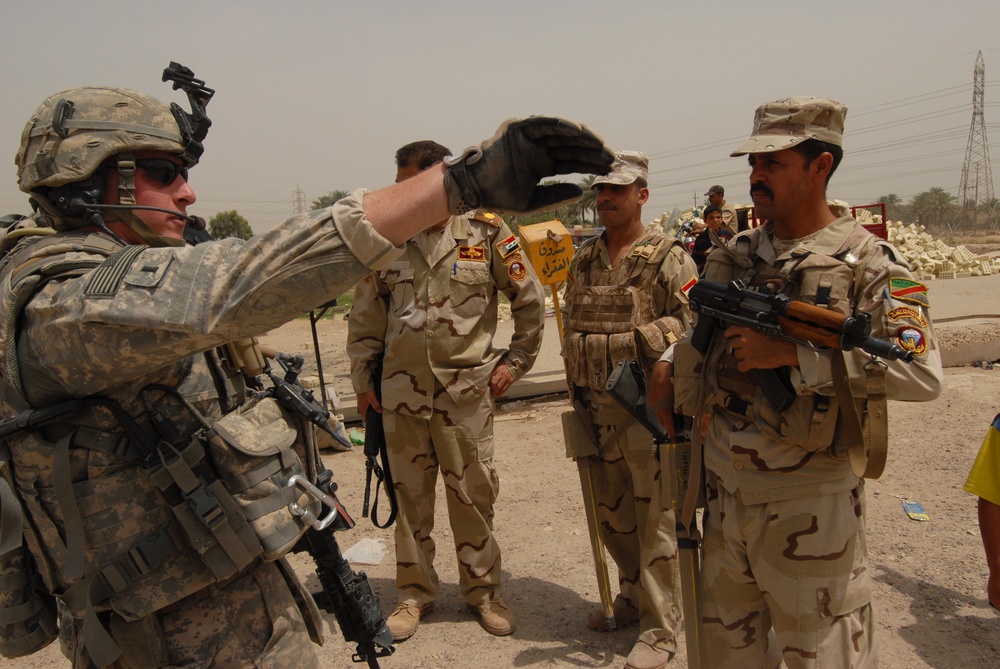 Iraqi soldiers plan a patrol through Abu Ghraib