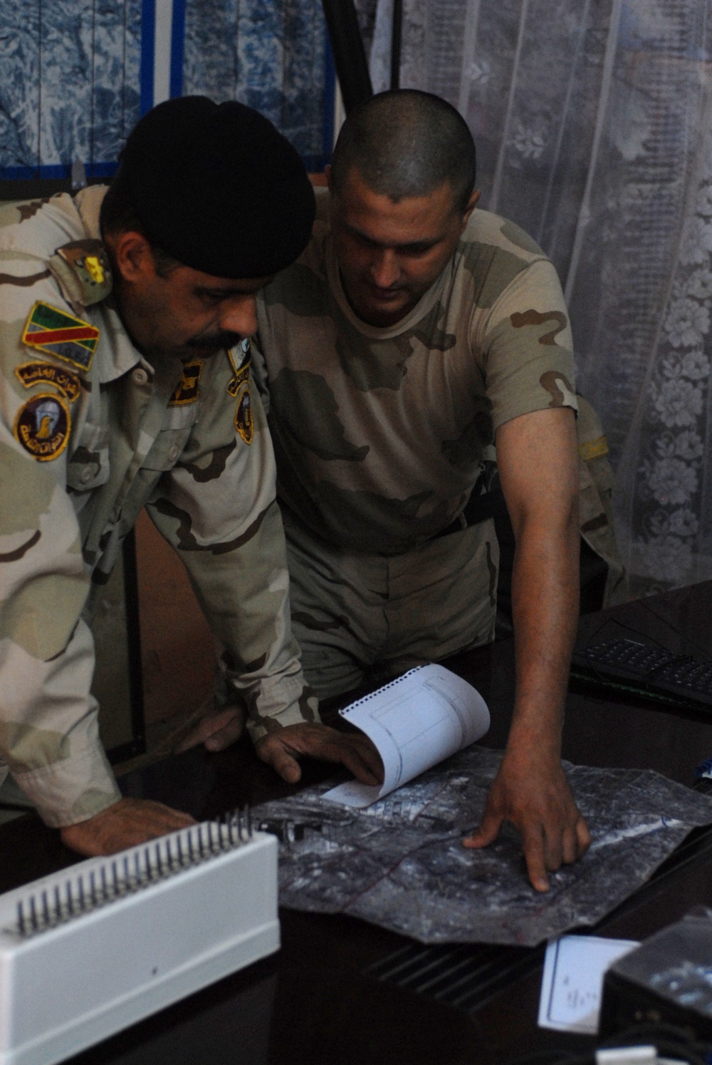 Iraqi soldiers plan a patrol through Abu Ghraib