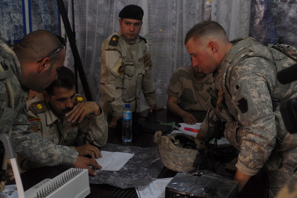 Iraqi soldiers plan a patrol through Abu Ghraib