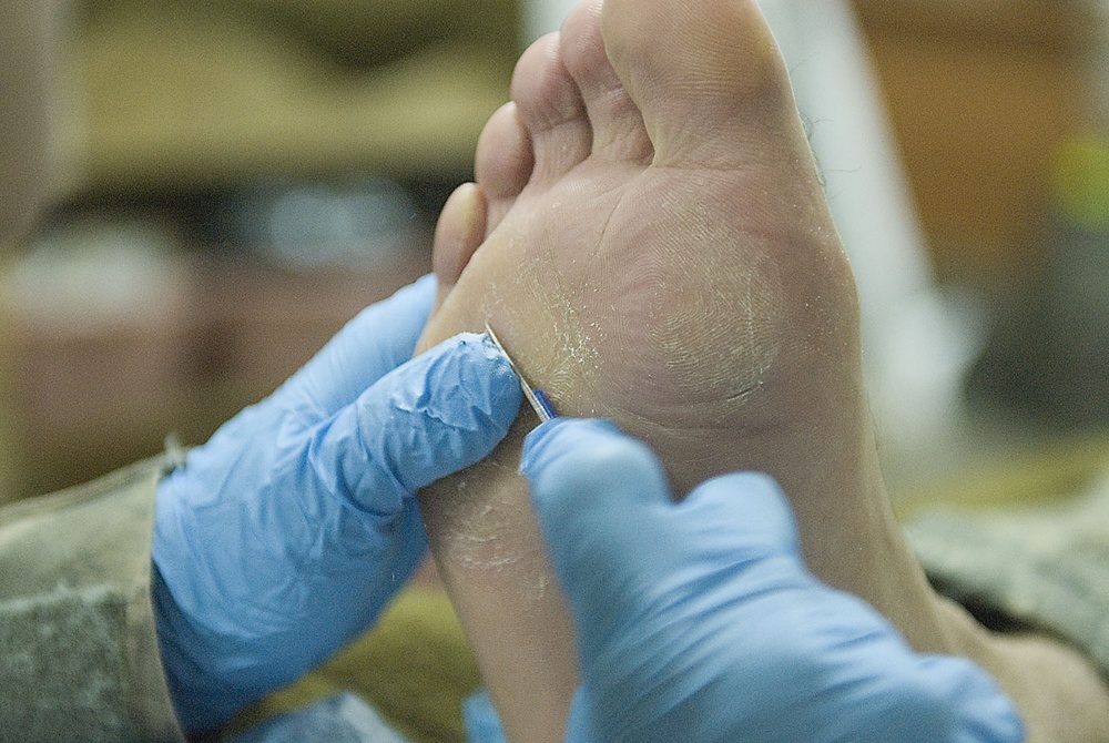 Soldier cleans fellow Soldier's feet