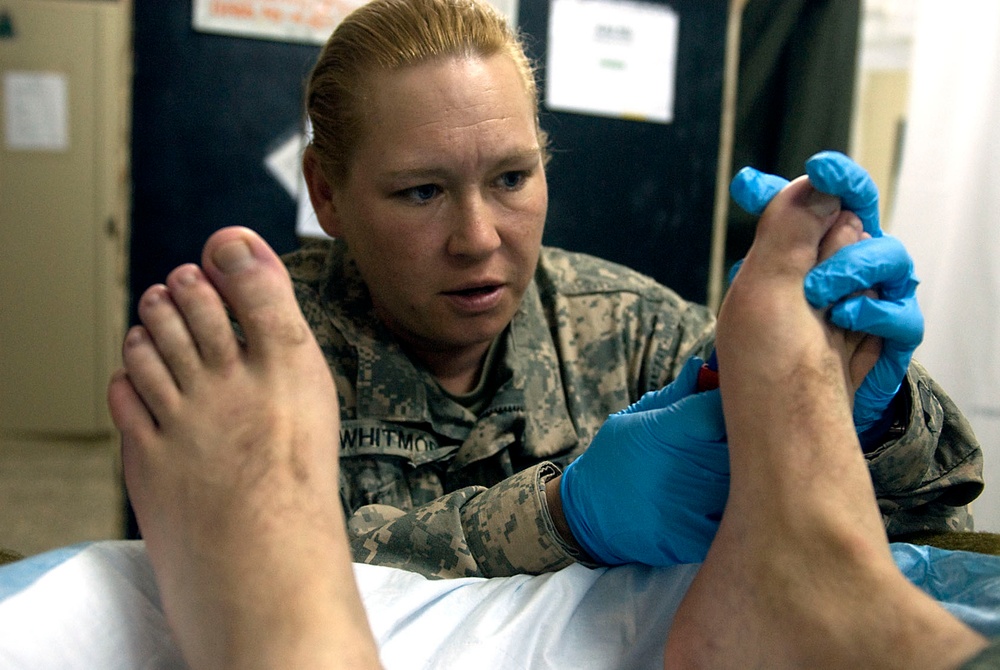 Soldier cleans fellow Soldier's feet