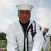 Seaman Apprentice Millad Green presents the flag. The flag is presented to the next of kin at the end of the funeral, usually by the military chaplain. If there is no next of kin present, the flag may be presented to the veteran's close friend or associat