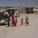 Iraqi children greet passing Marine patrol