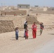 Iraqi children greet passing Marine patrol