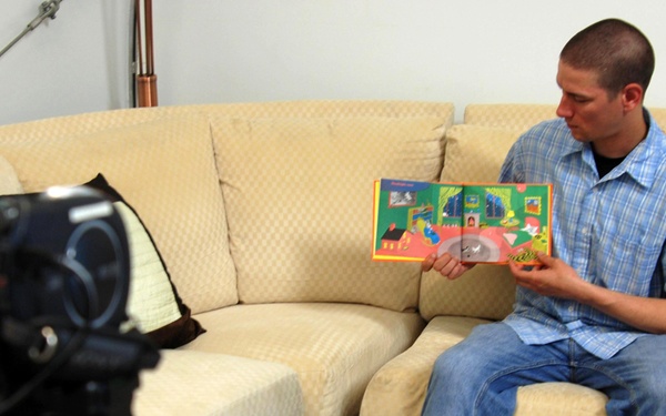 Soldier reads book for his children