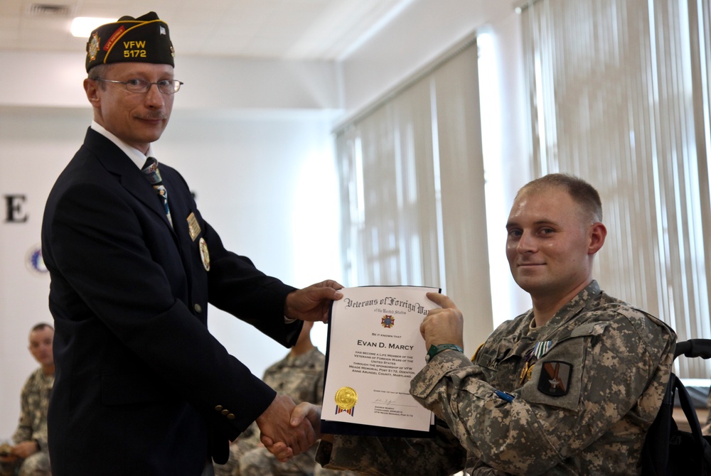 Andrew Murphy, commander, Veteran's of Foreign Wars Chapter 5172, Odenton, Md., presents U.S. Army Spc. Evan D. Marcy, 55th Signal Company (Combat Camera), with a lfetime membership during a ceremony in his honor at McGill Community Activity Center on For