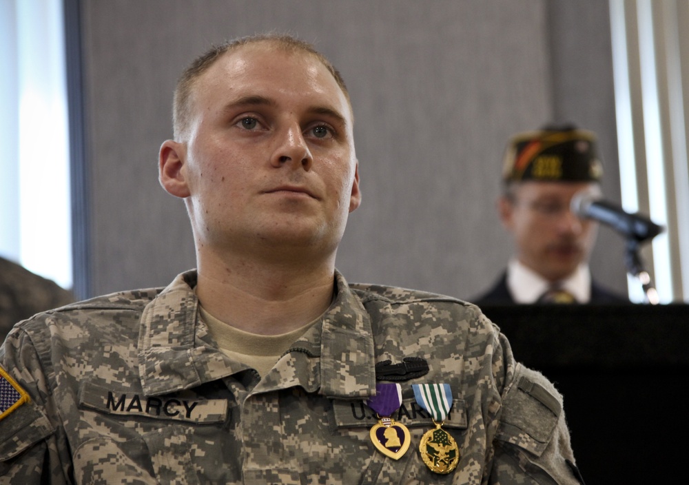 U.S. Army Spc. Evan D. Marcy, 55th Signal Company (Combat Camera), listens as Andrew Murphy, commander, Veteran's of Foreign Wars Chapter 5172, Odenton, Md., presents him with a lfetime membership during a ceremony in his honor at McGill Community Activit