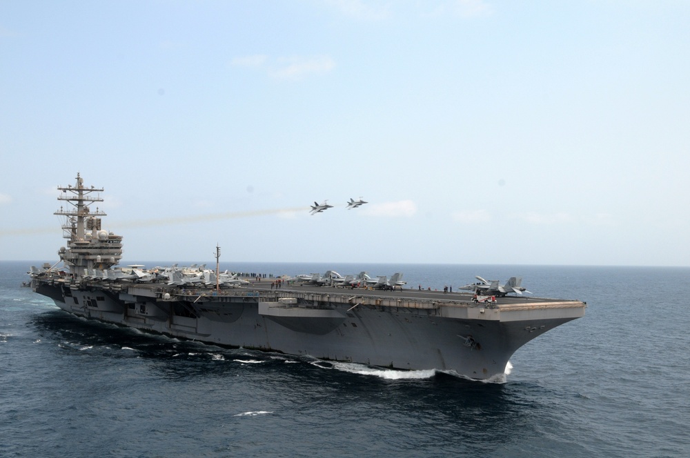 Aircraft fly over the Ronald Reagan