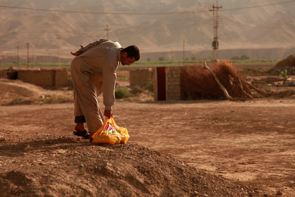 Iraqi soldiers hand out food in Tal Adh Dhah