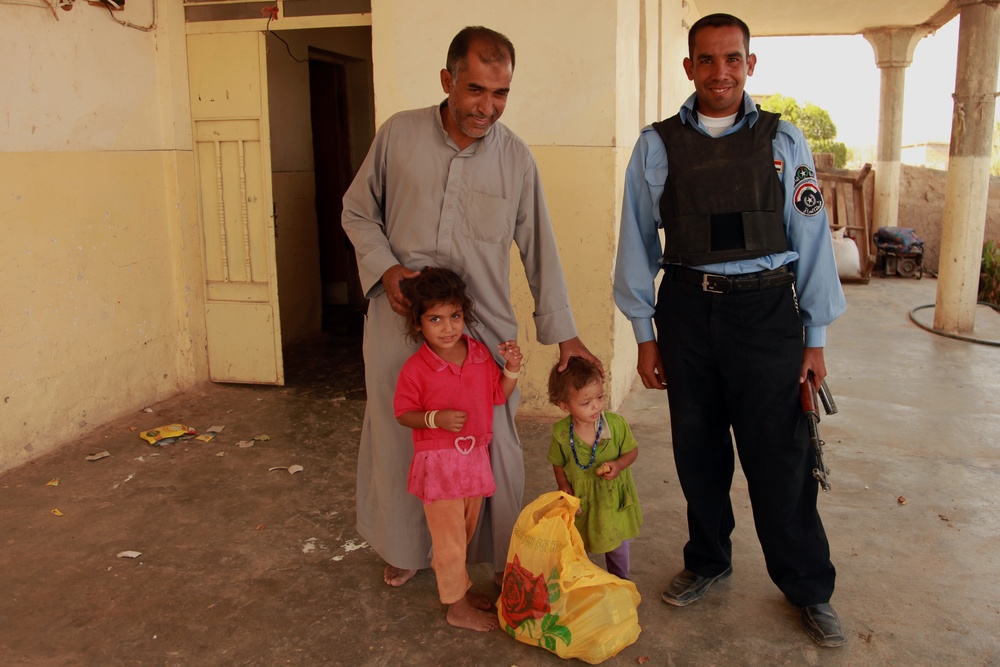 Iraqi soldiers hand out food in Tal Adh Dhah