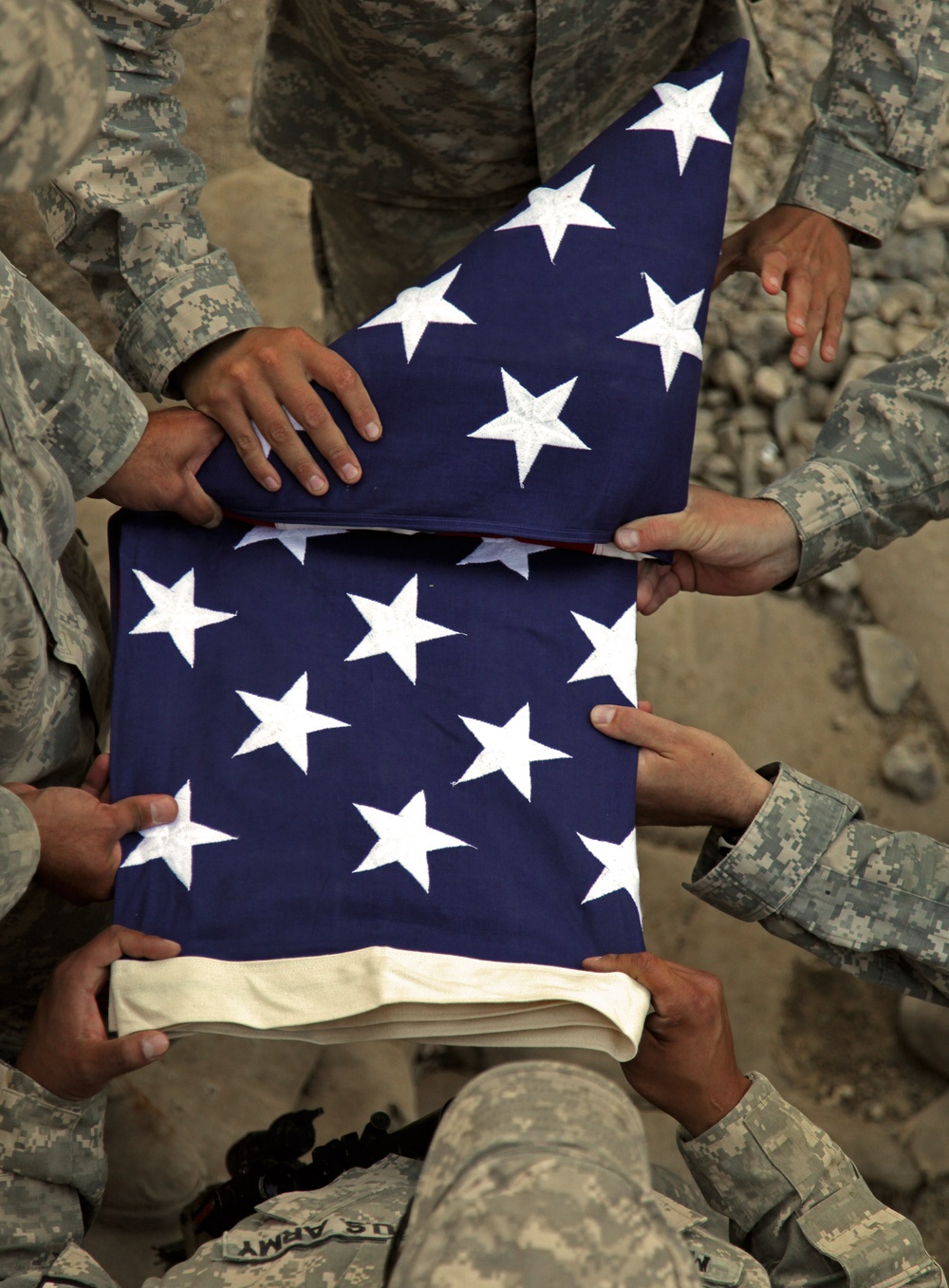 Soldiers fold flag for reenlistment
