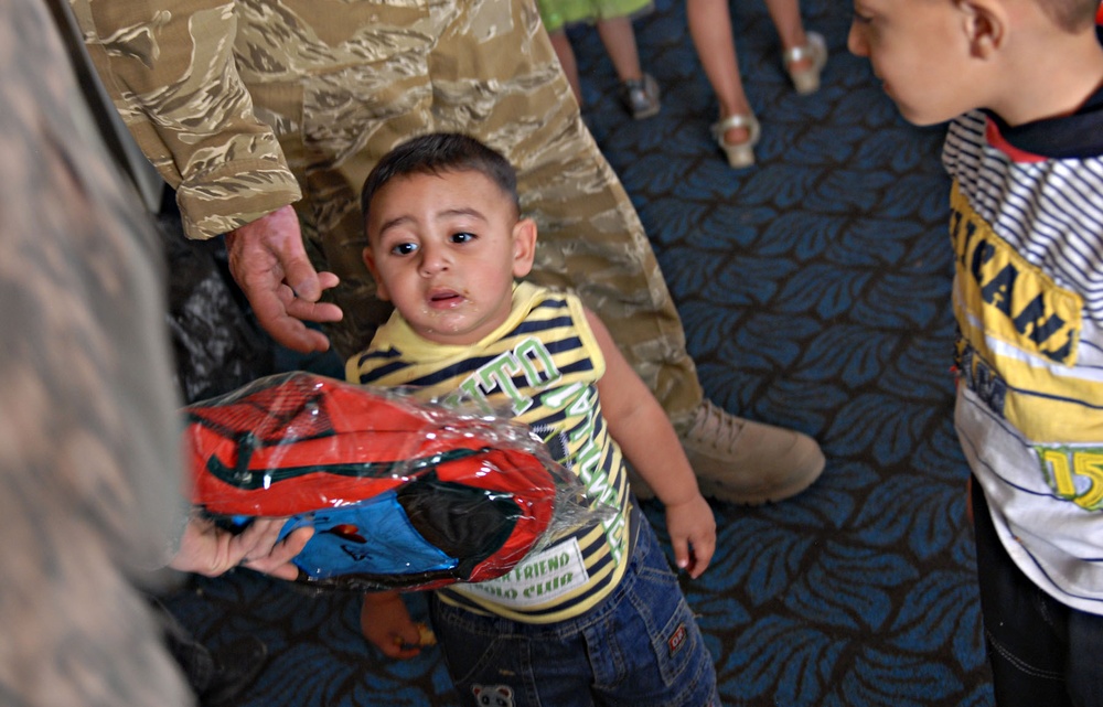 U.S. and Iraqi Soldiers bring backpacks to Baghdad kindergarten