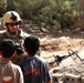 Soldiers give schoolchildren backpacks