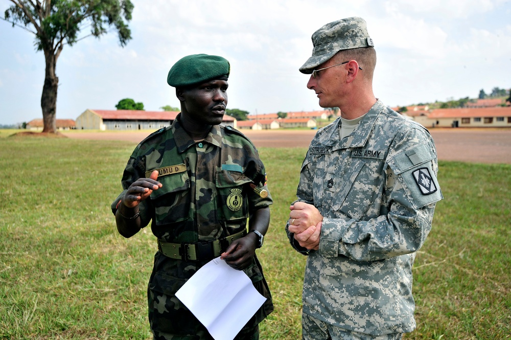 Sgt. 1st Class William Strobeck talks to Uganda Peoples Defense Force Chief Warrant Officer Donald Okumu.