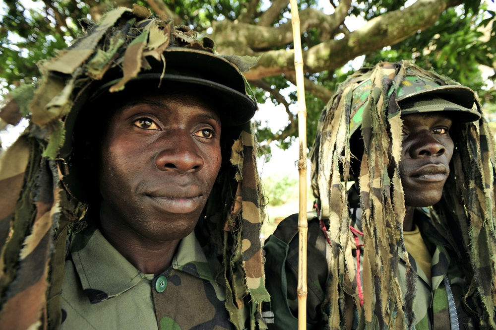 Uganda Peoples Defense Force soldiers stand beneath a tree during a demonstration of skills learned during the UPDF Non-Commissioned Officers Academy in Jinja.