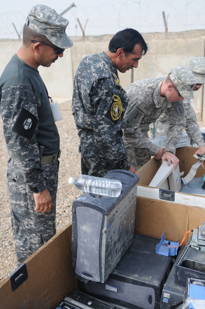 Iraqi policemen sort through equipment for sale, meet with soldiers and airmen