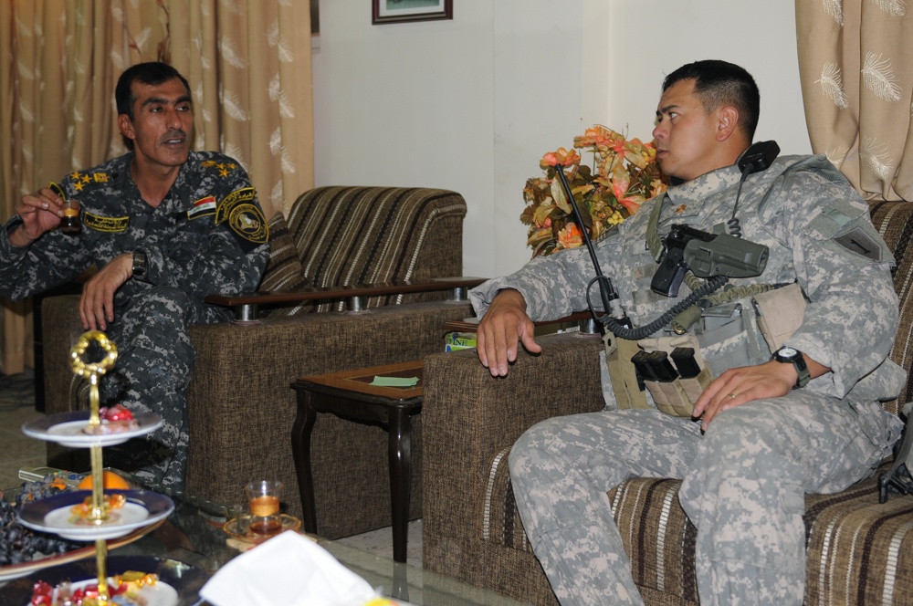 Iraqi policemen sort through equipment for sale, meet with soldiers and airmen