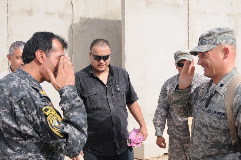 Iraqi policemen sort through equipment for sale, meet with soldiers and airmen