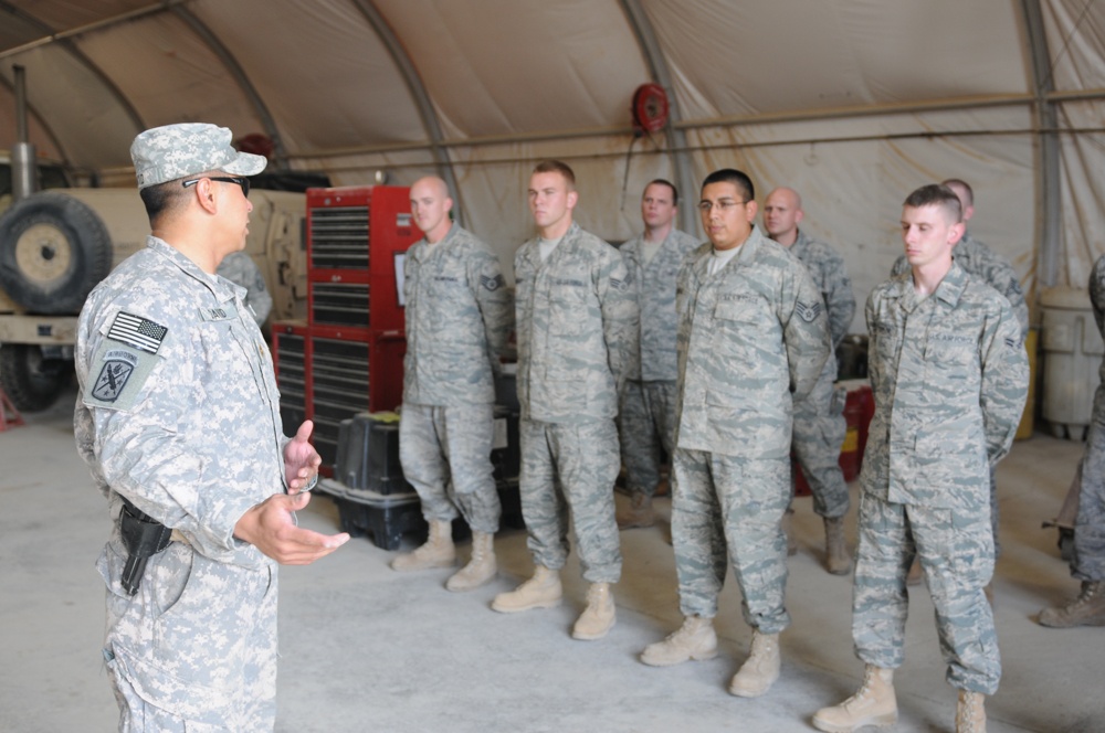 Iraqi policemen sort through equipment for sale, meet with soldiers and airmen