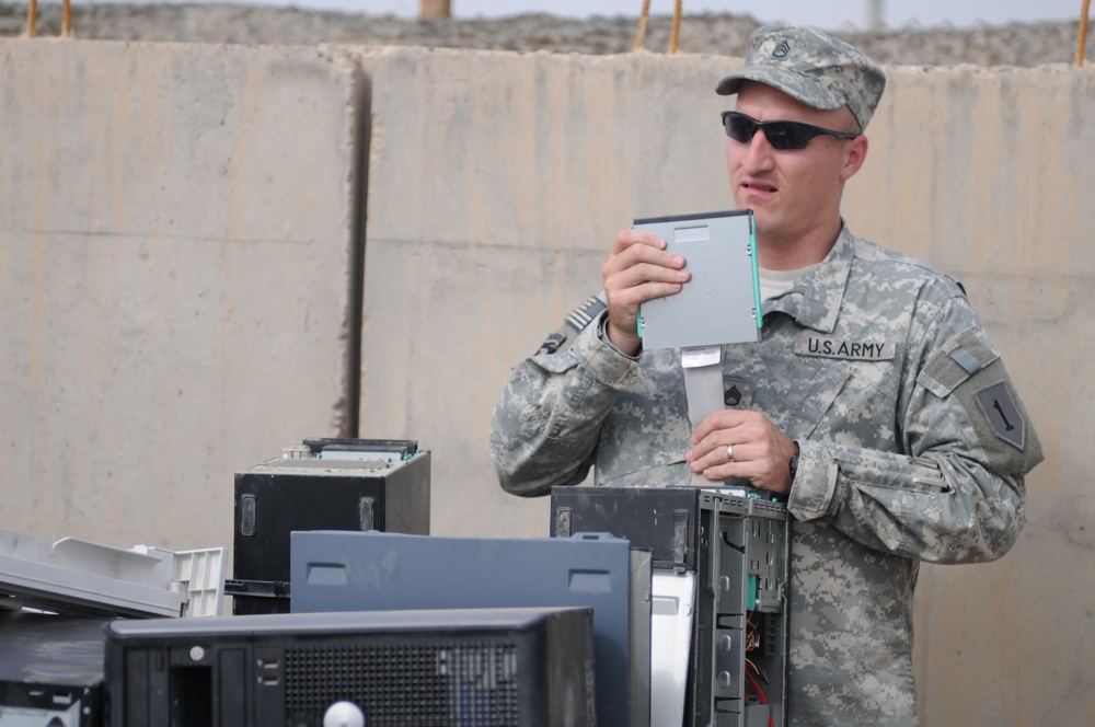 Iraqi policemen sort through equipment for sale, meet with soldiers and airmen