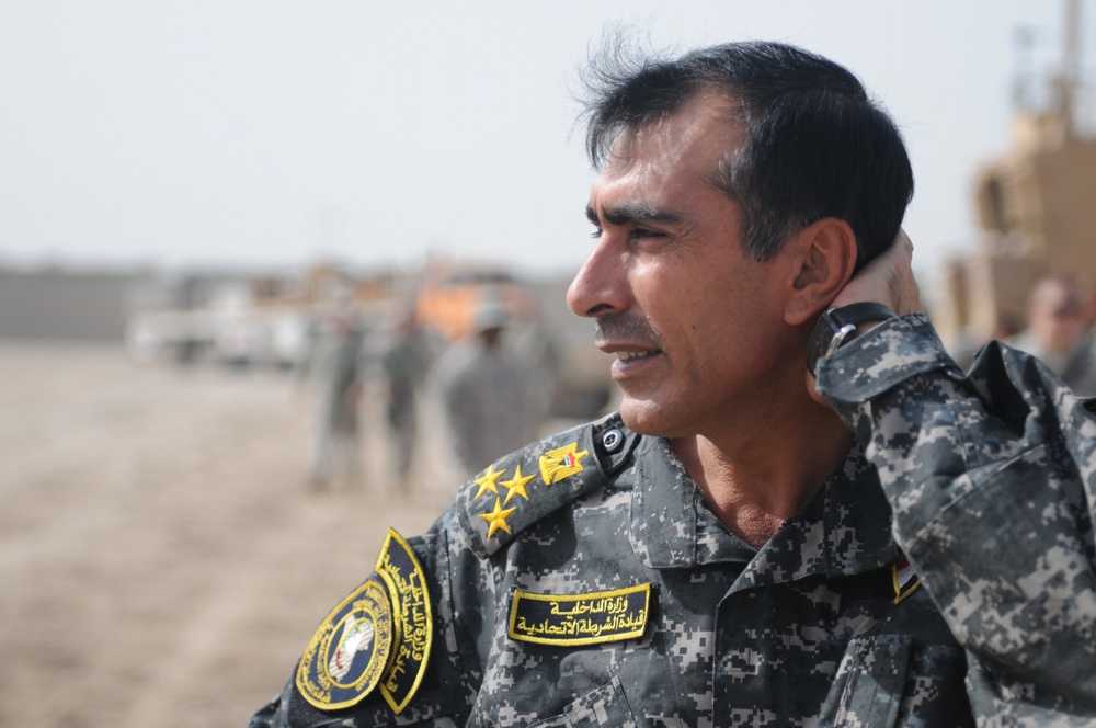 Iraqi policemen sort through equipment for sale, meet with soldiers and airmen