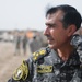 Iraqi policemen sort through equipment for sale, meet with soldiers and airmen