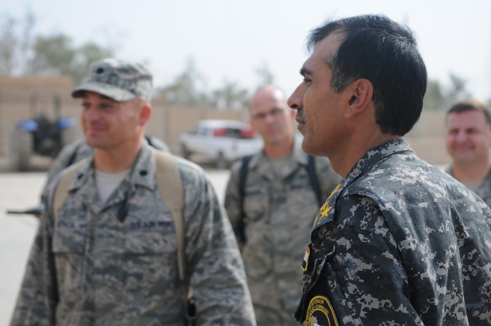Iraqi policemen sort through equipment for sale, meet with soldiers and airmen