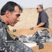 Iraqi policemen sort through equipment for sale, meet with soldiers and airmen