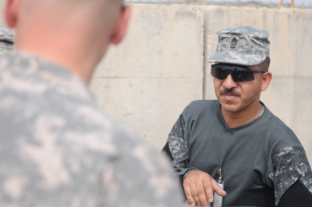 Iraqi policemen sort through equipment for sale, meet with soldiers and airmen