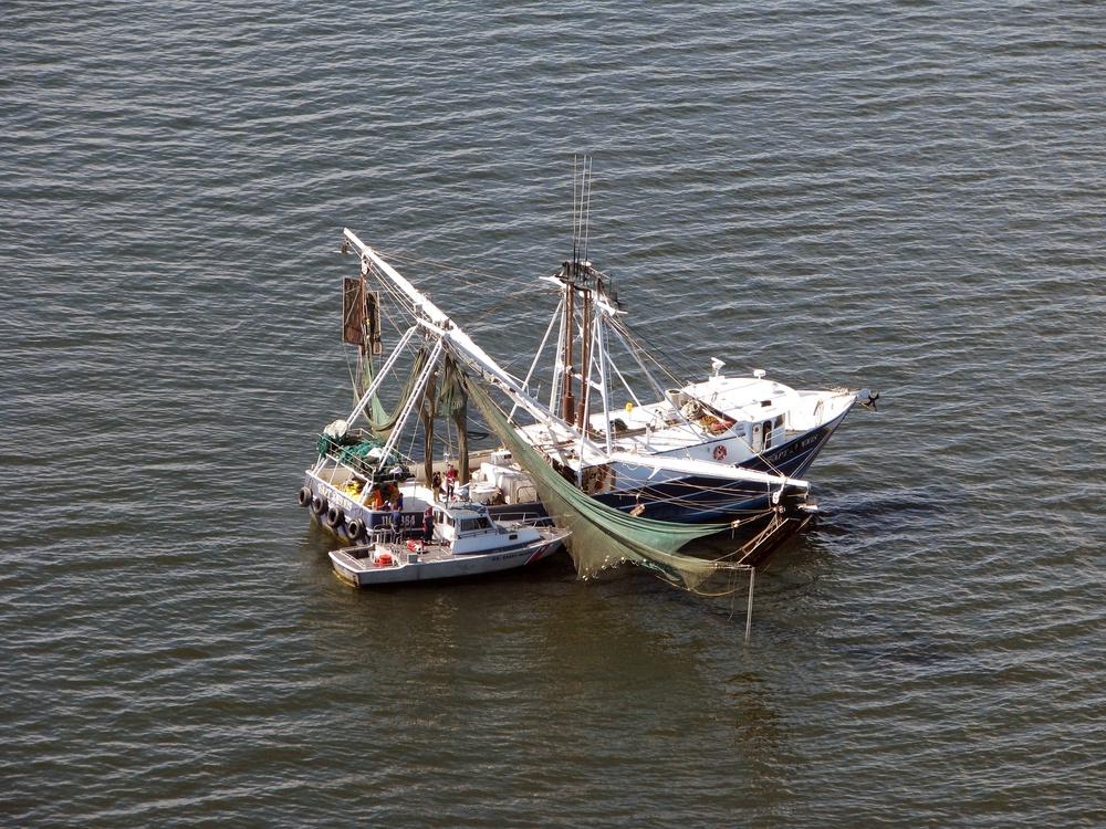 US Coast Guard Small Boat Assists Man With Leg Injury