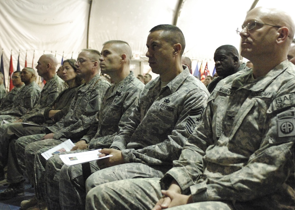 Brigadier General Steve Kwast, 455th Air Expeditionary Wing commander and Chief Master Sgt. Jeffrey Cui, 455th AEW command chief listen to Army Sgt. First Class Raleigh Sell, the protocol non-commissioned officer in charge from Combined Joint Task Force 8