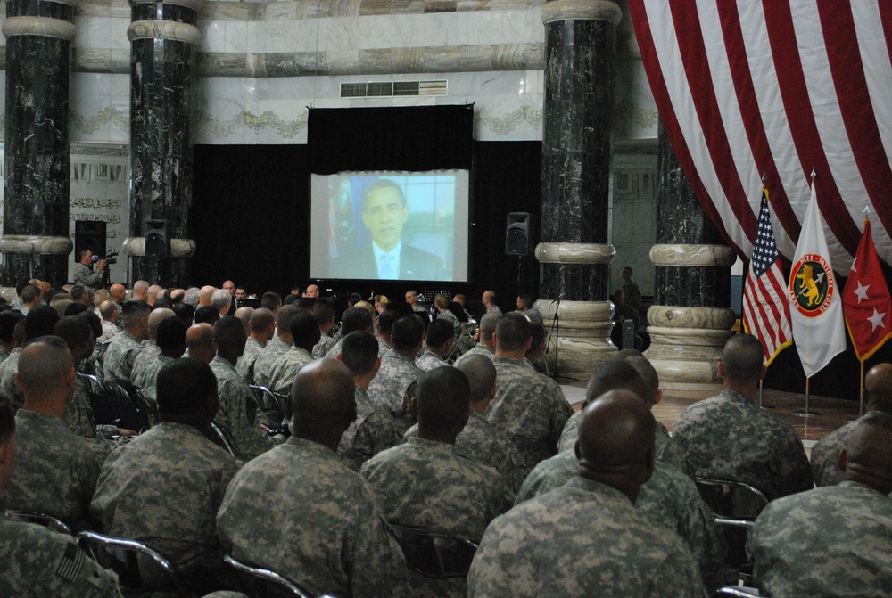 Service members listen to the message of their commander-in-chief, President Barrack Obama, before receiving their citizenship during the naturalization ceremony held at Victory Base Camp, Iraq.  Six Soldiers from the 37th Eng. Bn. - JTF Eagle became U.S.
