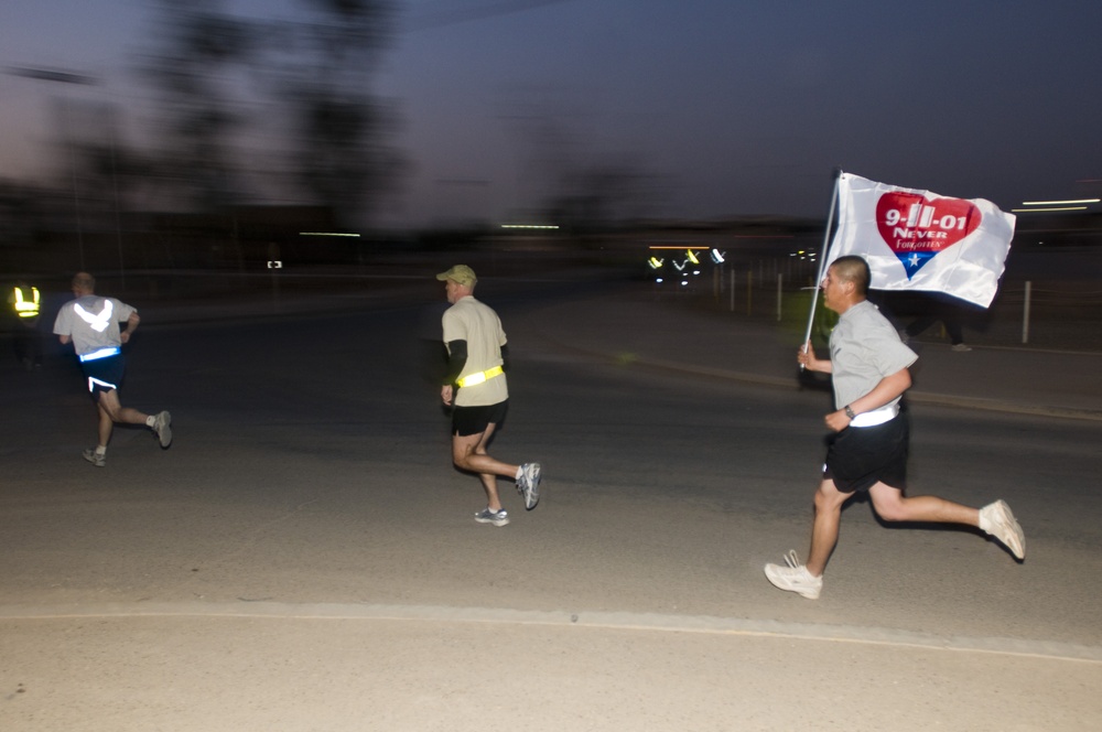 A Soldier carries a Sept. 11, 2001 remembrance flag, donated by the Apollo Flag company in Totowa, N.J., during the Veterans Day 5K race Nov. 11 at Joint Base Balad, Iraq.