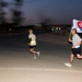A Soldier carries a Sept. 11, 2001 remembrance flag, donated by the Apollo Flag company in Totowa, N.J., during the Veterans Day 5K race Nov. 11 at Joint Base Balad, Iraq.