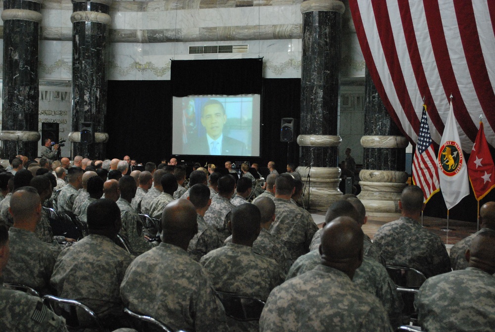 Servicemembers listen to the message of their Commander in Chief, President Barack Obama, before receiving their citizenship during the Naturalization Ceremony held at Victory Base Camp, Iraq. 6 Soldiers from the 37th Eng. Bn. - JTF Eagle became U.S. Citi