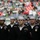 New York Jets Vs Jacksonville Jaguars Military Ceremony A group of U.S. Navy sailors in dress uniform (Service Dress Blue) are standing in formation on what appears to be a sports stadium field. The sailors are wearing their distinctive white Dixie cup covers and dark navy uniforms adorned with various ribbons, badges, and rank insignia. A large crowd of spectators is visible in the blurred background, suggesting this is a ceremonial appearance at a public sporting event.