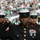 New York Jets Vs Jacksonville Jaguars Military Ceremony Three United States Marines in dress blue uniforms are standing in formation at what appears to be a professional football stadium. The central Marine is rendering a salute with a white-gloved hand while displaying multiple service ribbons and medals on his chest. The setting suggests a ceremonial appearance, likely during a pre-game or halftime event.