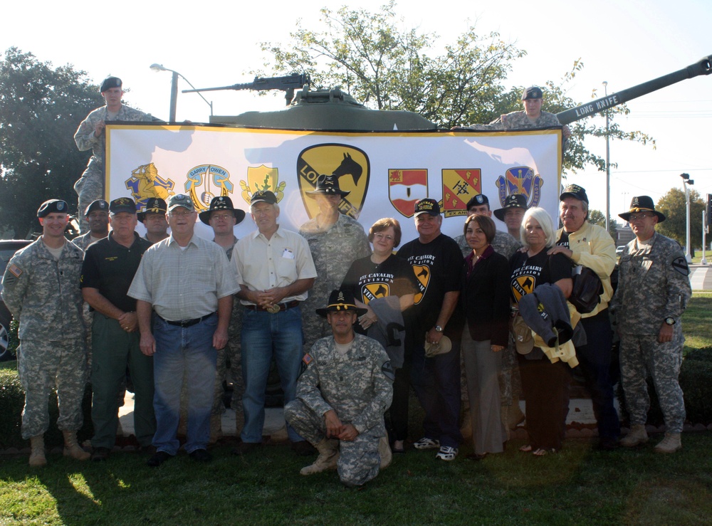 Unit members, assigned to the 4th Brigade Combat Team, 1st Cavalry Division &quot;Long Knives,&quot; along with former Vietnam Veterans and spouses pose for a group picture in front of the unit's headquarters as part of a Veteran's day tribute and effort to reach o