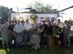 Unit members, assigned to the 4th Brigade Combat Team, 1st Cavalry Division "Long Knives," along with former Vietnam Veterans and spouses pose for a group picture in front of the unit's headquarters as part of a Veteran's day tribute and effort to reach o