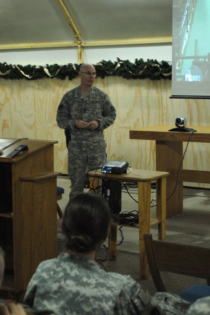 Capt. John Donovan, Red Bull Visitor's Bureau and event coordinator, addresses the Soldiers attending the Soldier assistance video teleconference at Contingency Operating Base Basra, Dec. 17. In conjunction with the community of St. Cloud, Minn., the 34th