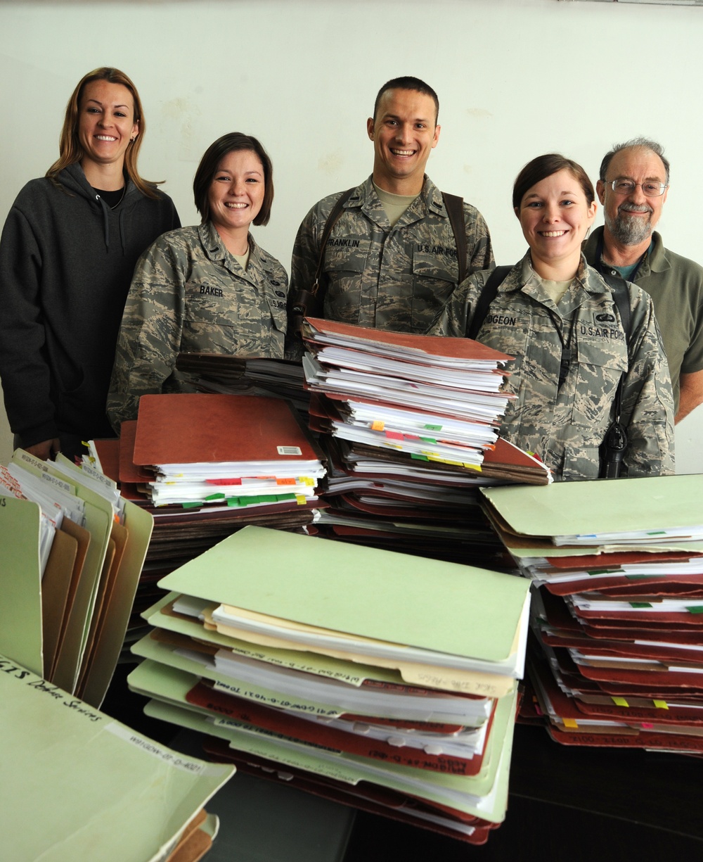 Theater Wide Internal Security Services team stands next to contracts