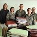 Theater Wide Internal Security Services team stands next to contracts